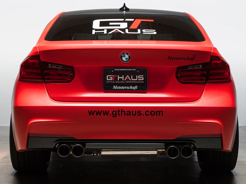 Meisterschaft license frame and GTHAUS license plate on a BMW, showcasing a premium performance exhaust system.