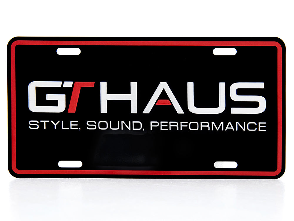 GTHAUS license plate featuring a bold black background with white and red text highlighting style, sound, and performance.