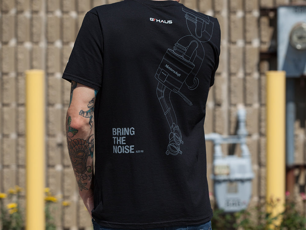 Black MEISTERSCHAFT T-shirt featuring an Audi R8 exhaust design on the back with "BRING THE NOISE" text.