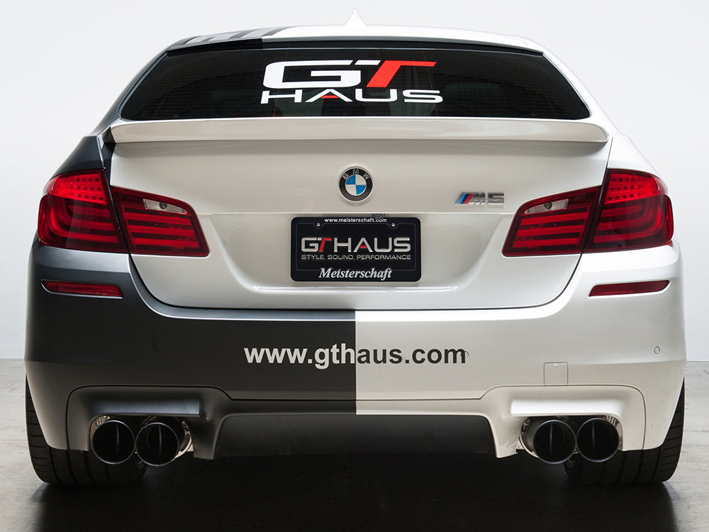 Meisterschaft license frame and GTHAUS license plate on a BMW M5, showcasing premium exhaust system branding.