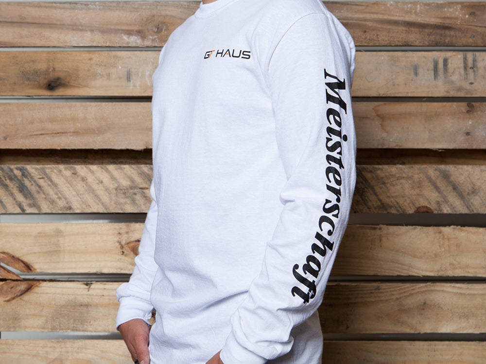 White long-sleeve GTHAUS T-shirt featuring the logo on the front and "Meisterschaft" printed on the sleeve.