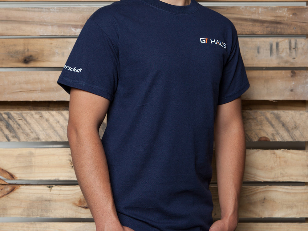 Navy GTHAUS T-shirt displayed on a model, featuring the GTHAUS logo on the chest and sleeve.